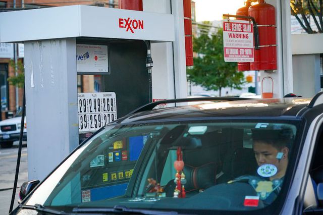 A man in a sedan sits next to a gas pump at a gas station in Flushing.